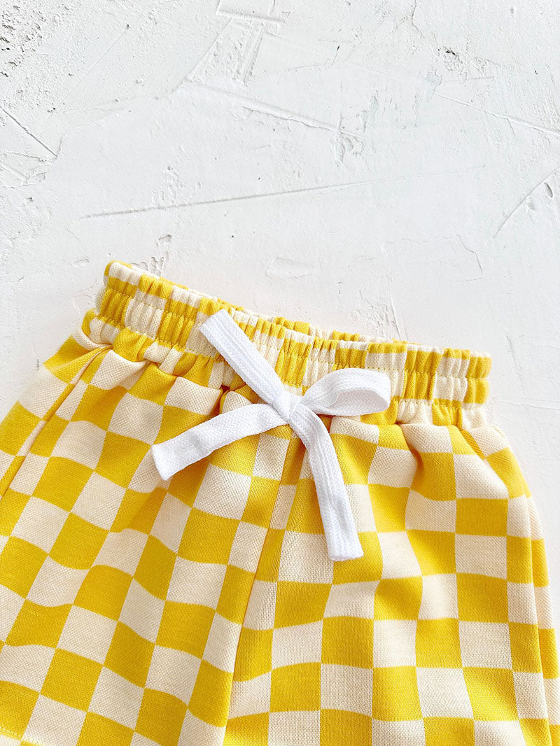 Mellow Mini kledingset 0-3 jaar: T-shirt en geblokte broek in geel, blauw, paars of groen. Duurzaam, comfortabel en perfect voor de zomer!